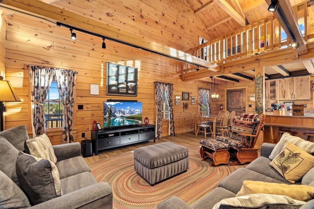 Un intérieur chaleureux de chalet en bois, comprenant un salon, un coin repas et une cuisine.