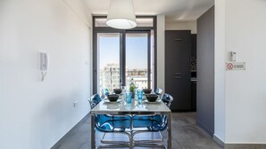 A modern dining area with a table set for four, large windows, and a view of the cityscape. - Maryam's 2-BR Apt Facing Larnaca Harbor W/ Pool (Cyprus - Larnaca)