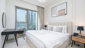 Habitación de hotel moderna con una cama grande, un escritorio y vistas a la ciudad.