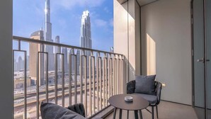 Un balcón con vistas al Burj Khalifa, un sofá, una silla y una mesita.