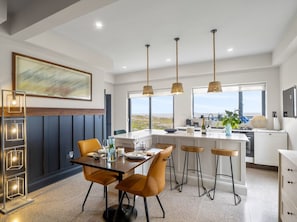 Une cuisine moderne avec un coin repas, de grandes fenêtres et une vue sur le paysage.
