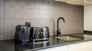 Eine Küche mit modernem Design, mit einer schwarzen Arbeitsplatte, einem eingebauten Toaster und einem Spülbecken.