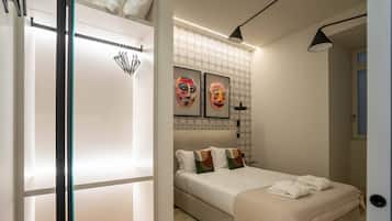 Un dormitorio moderno con una cama, un armario y dos máscaras enmarcadas en la pared.