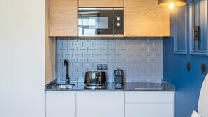 Eine moderne Küche mit Holzausstattung, einer Bosch-Mikrowelle, einer Kaffeemaschine und einem Toaster.