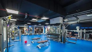 Une salle de sport équipée de divers appareils d’exercice, de bancs et d’haltères.