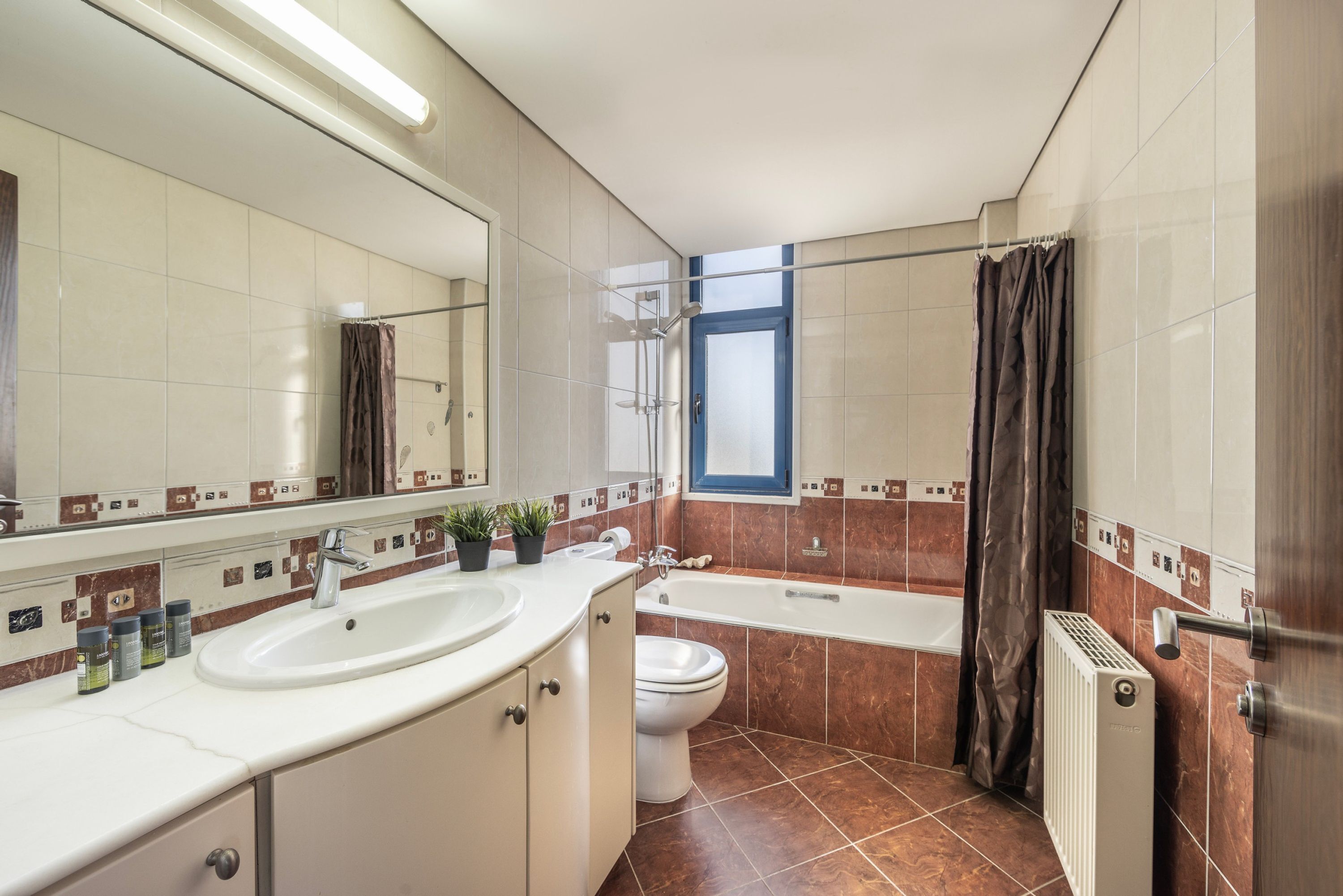 A modern bathroom with a sink, toilet, and bathtub.