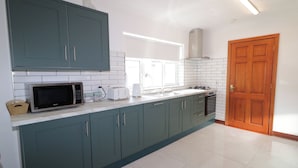 Une cuisine avec des armoires de couleur turquoise, un four à micro-ondes, un grille-pain et une cuisinière.