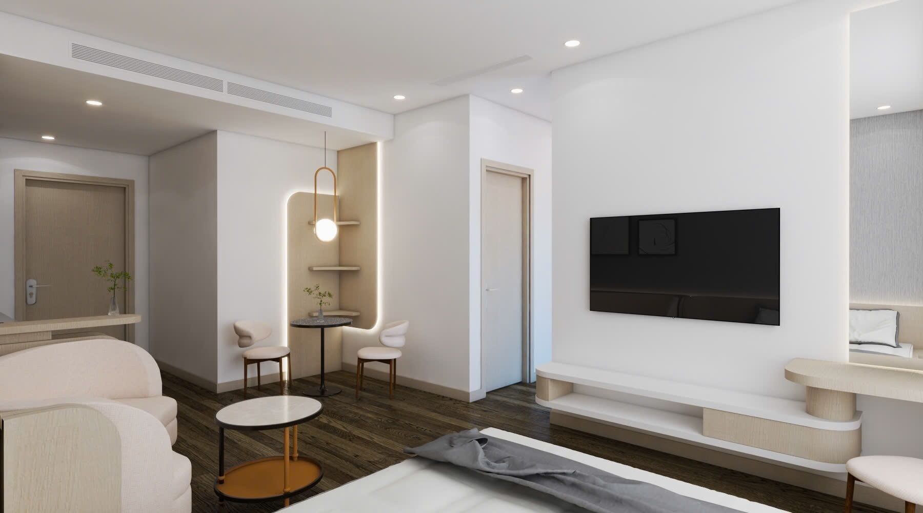 A modern hotel room with a flat-screen TV mounted on the wall, a sofa, a coffee table, and a small side table.