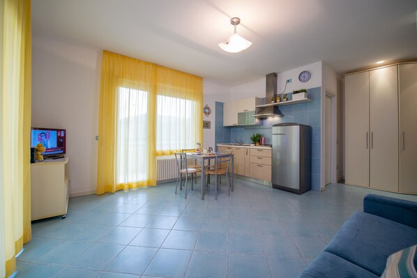 Un espace de vie compact comprenant un coin repas, une kitchenette et un canapé.