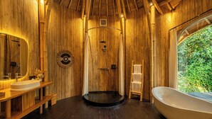 Un intérieur en bois avec une baignoire, une douche et un meuble-lavabo avec un miroir.