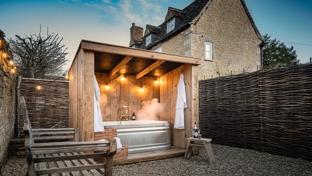 A rustic wooden sauna with a large steam bath, wooden benches, and a wicker basket. - Fabulously presented dog friendly holiday cottage with outside tub - The Coach House, South Cerney (South Cerney)