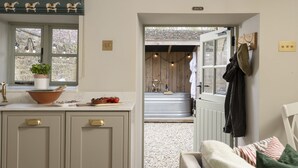 A kitchen with a bowl, a potted plant, and a window with a view. - Fabulously presented dog friendly holiday cottage with outside tub - The Coach House, South Cerney (South Cerney)