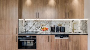 Een moderne keuken met houten kastjes, een marmeren spatwand en geïntegreerde apparatuur, waaronder een Siemens vaatwasser en oven.