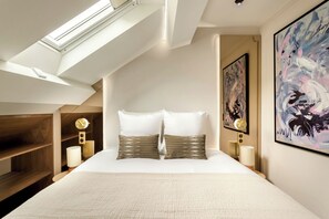 A modern bedroom with a skylight, a large bed with two pillows, wooden shelving, and two wall-mounted clocks. - Merveil - Luxury Suite - Champs Elysees - St Cyr I (Paris)