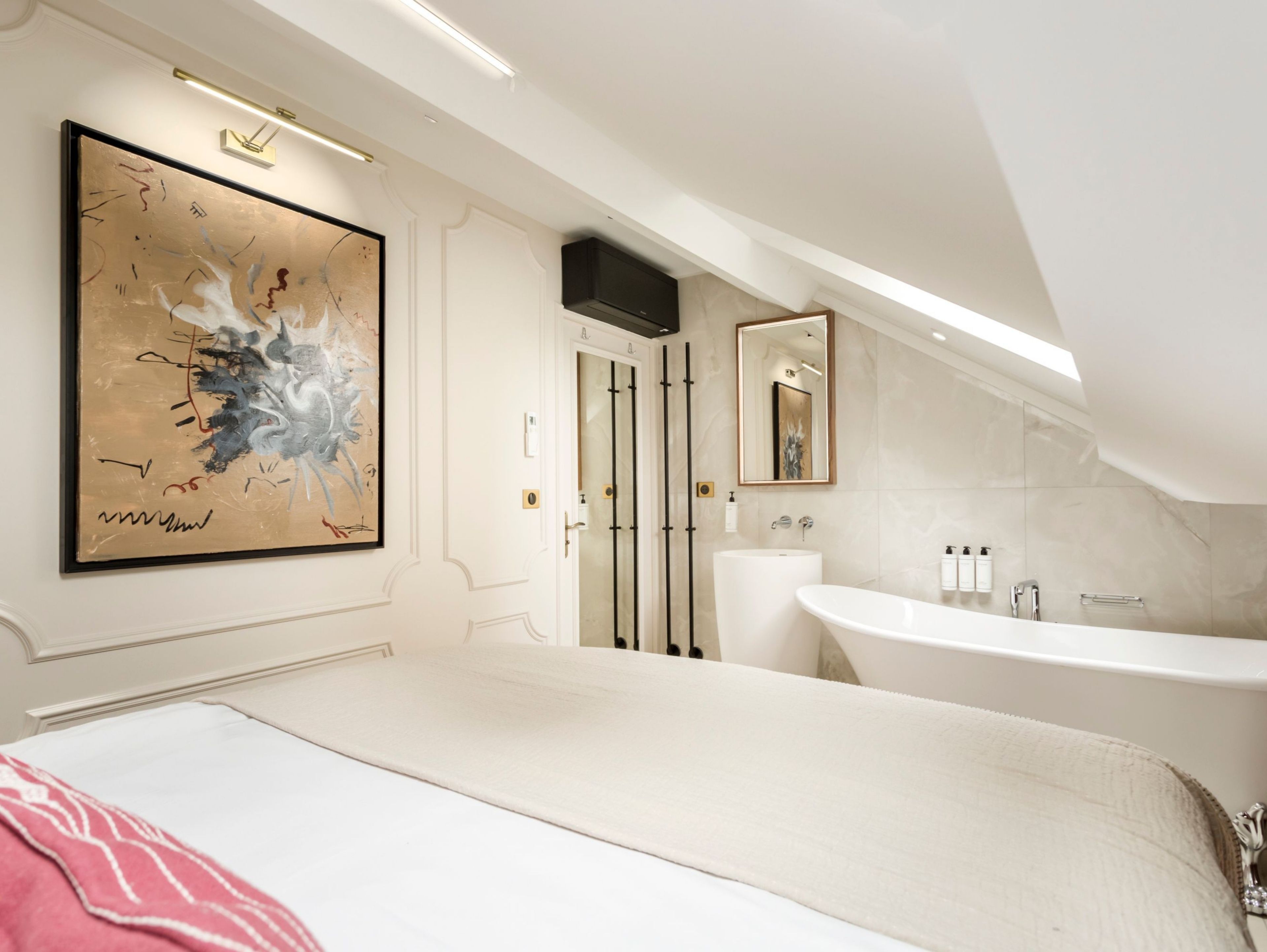 A modern bathroom with a large bathtub, a separate shower area, and a large mirror.