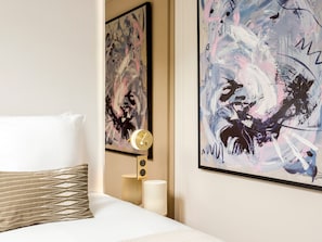 A hotel room with a bed, a clock, and abstract paintings on the wall. - Merveil - Luxury Suite - Champs Elysees - St Cyr I (Paris)