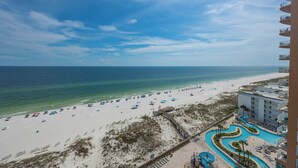 Ein Strandresort mit Swimmingpool, Strandliegen und Blick auf das Meer.