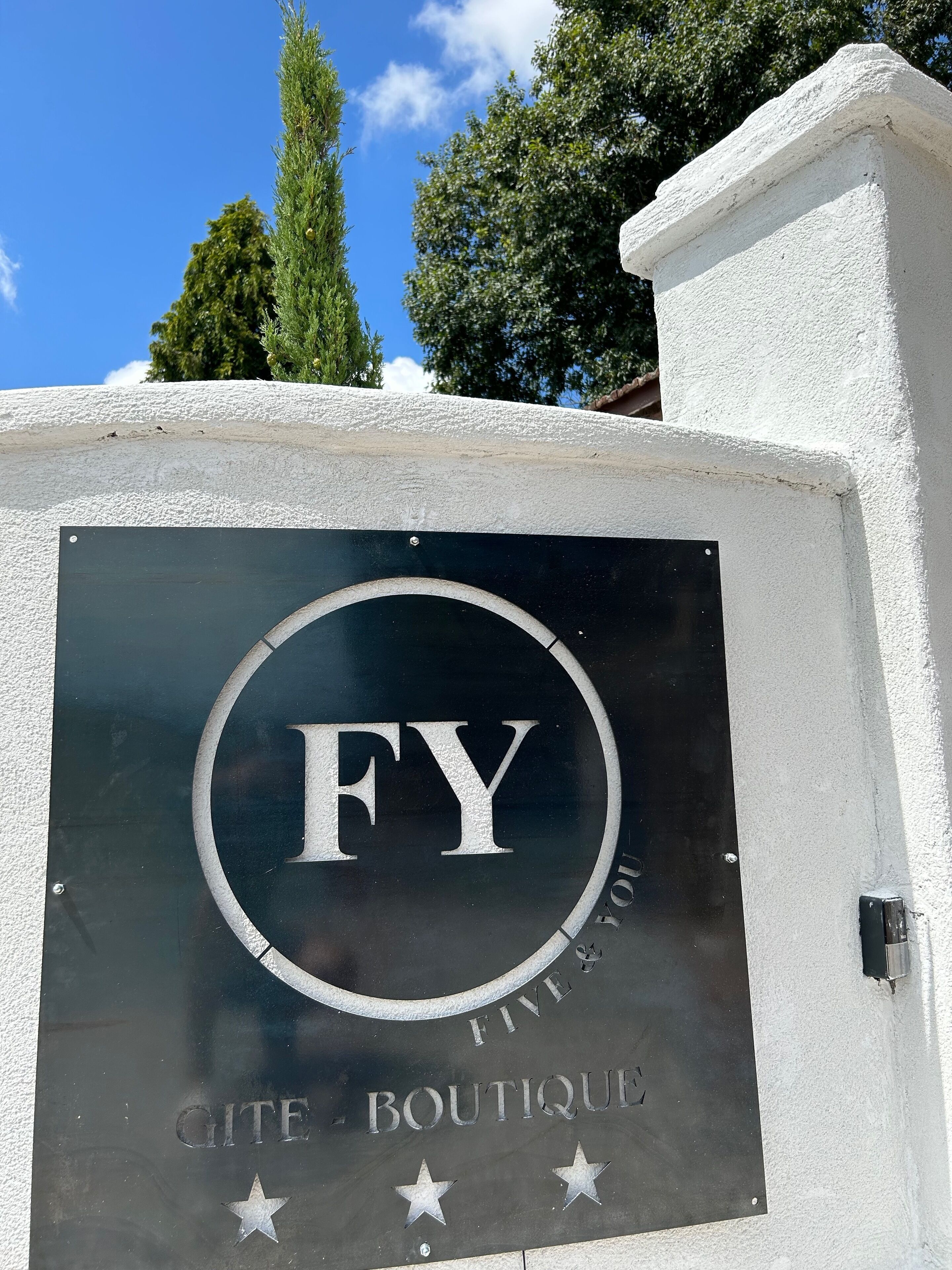 A sign for 'FY Boutique' with a circular logo and stars below.