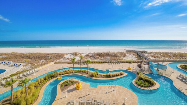 Een resort met een zwembad, toegang tot het strand en een helder uitzicht op de oceaan.