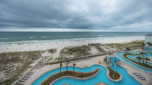 Un resort frente al mar con una amplia playa de arena, una zona de piscina y vistas al océano.