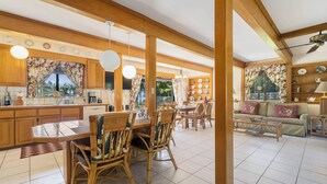 Una cocina amplia con armarios de madera, un comedor con mesa y sillas, y una sala de estar con sofá y mesa de centro.