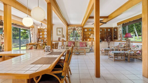 Un espacio habitable amplio con una gran mesa de comedor de madera, asientos cómodos y vistas al exterior.