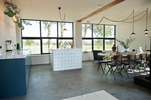 Enjoy meals in the spacious kitchen and dining area with a large island, sink, and window offering a view of the outdoors.
