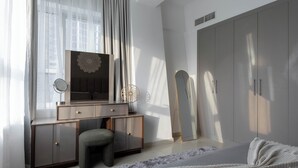 A bedroom with a bed, a vanity with a mirror, a dresser, and a wardrobe. - Handsome 1BR in Armada Tower 3 (Dubai)
