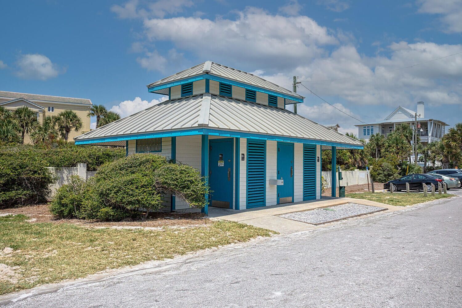 A small, single-story building with a blue and white color scheme, a flat roof, and a small porch area.