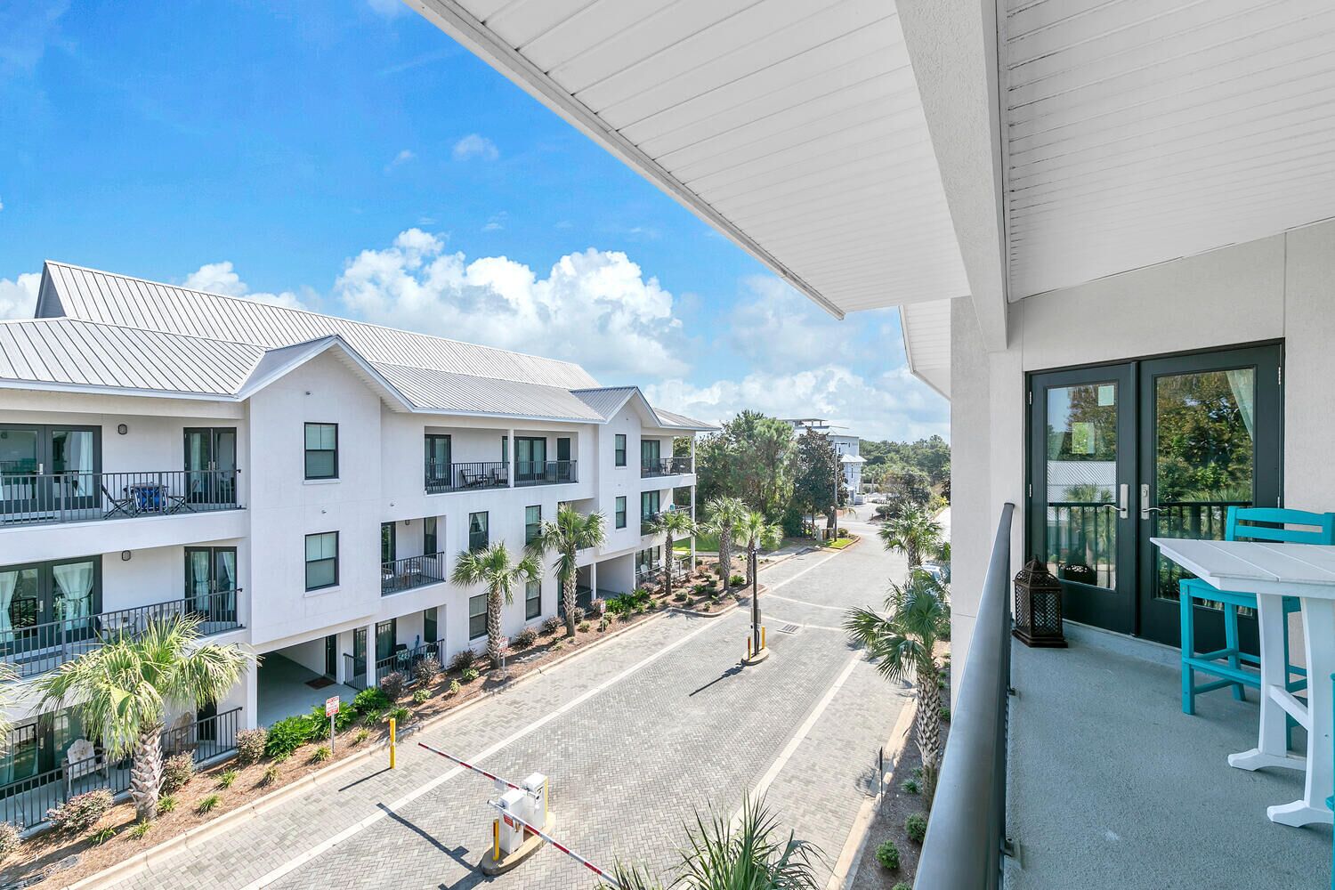 A modern hotel with multiple balconies, a paved street, and a clear view of the surrounding area.