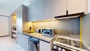 A modern kitchen with a dishwasher, stove, and microwave.