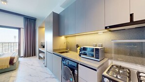 A modern kitchen with a built-in dishwasher, microwave, and stove. - Mag Eye 920 - Classy Studio Apartment in Meydan (Meydan)