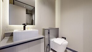 Ein modernes Badezimmer mit Waschbecken, Spiegel und Toilette in Weiß.