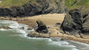 Une plage côtière avec des formations rocheuses et une zone sablonneuse.