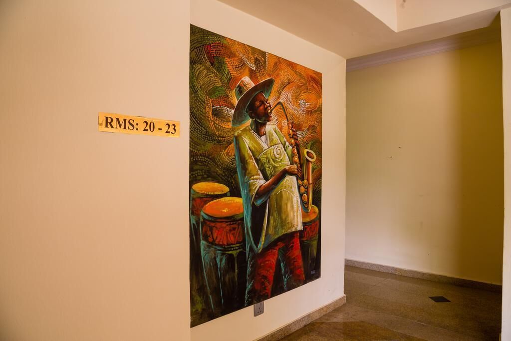 Un tableau représentant une personne jouant du saxophone, avec une étiquette sur le mur indiquant « RMS : 20-23 ».