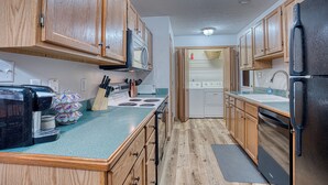 A compact kitchen with wooden cabinets, a microwave, a stove, a refrigerator, and a dishwasher. - Retro '90s 2BR/2BA • Private Entrance • Pet-Friendly • King Bed • 5 M... (Newburgh)