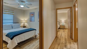 A bedroom with a bed, bedside tables, a ceiling fan, and a wooden floor. - Retro '90s 2BR/2BA • Private Entrance • Pet-Friendly • King Bed • 5 M... (Newburgh)