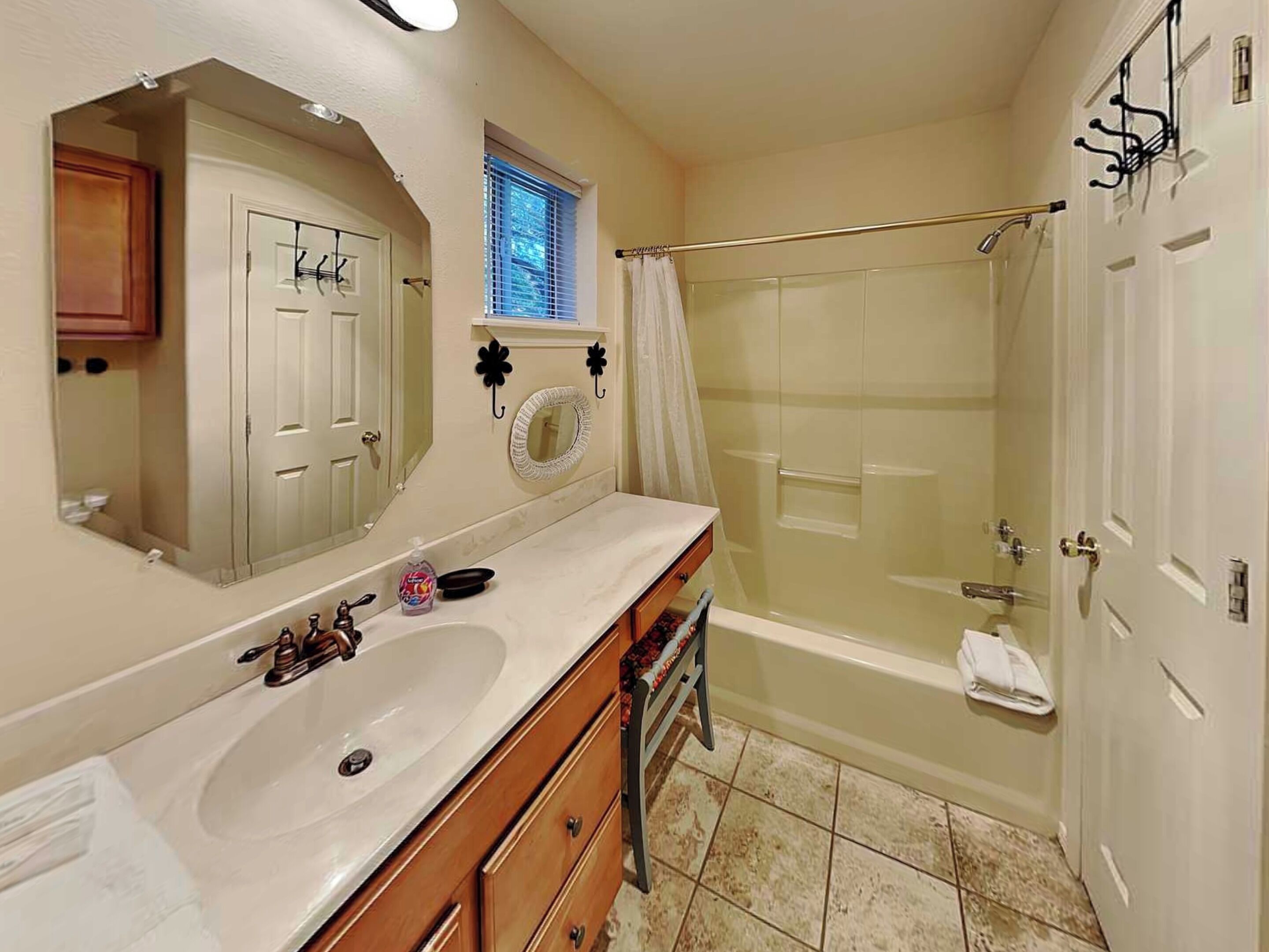 A bathroom with a double sink vanity, a shower with a glass door, and a mirror with a decorative frame.