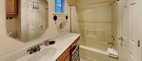 A bathroom with a double sink vanity, a shower with a glass door, and a mirror with a decorative frame.