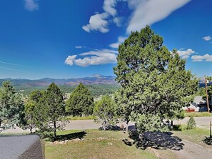 A landscape with a prominent tree in the foreground, a clear blue sky, and distant mountains. - Tanglewood by Ruidoso Vacation Rentals (Ruidoso)