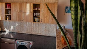Una cocina con armarios de madera, lavavajillas y salpicadero de azulejos.