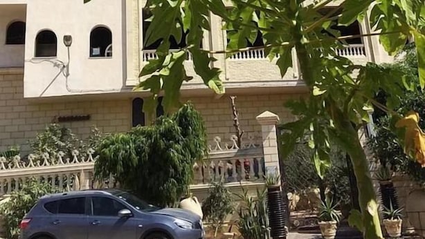 Un edificio con fachada blanca, múltiples ventanas y un letrero que dice 'Anbar Street'.