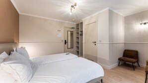 Un dormitorio con cama, armario y silla.
