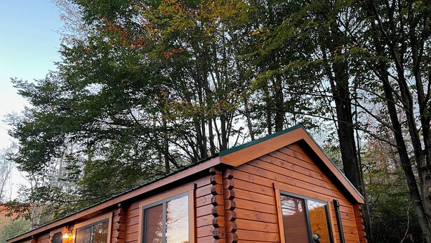 A wooden cabin with a pitched roof, large windows, and a central door. - The Cozy Cabin: Mountain Escape at Snowshoe, WV (Slaty Fork)