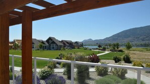 Un quartiere residenziale con case, cielo sereno e montagne sullo sfondo.