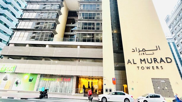 Ein modernes Hochhaus mit einem gut sichtbaren Schild für Al Murad Towers.