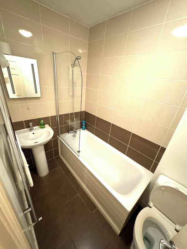 A modern bathroom with a bathtub, a sink, and a toilet.