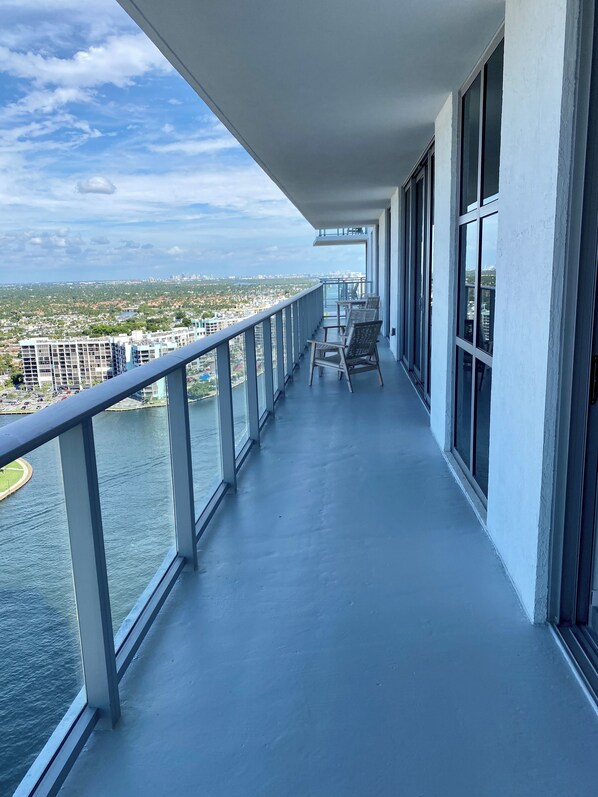 A balcony with a view of a cityscape and a body of water.