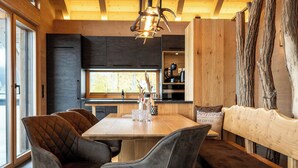 Una cocina moderna con armarios oscuros, una mesa de comedor de madera y un banco.
