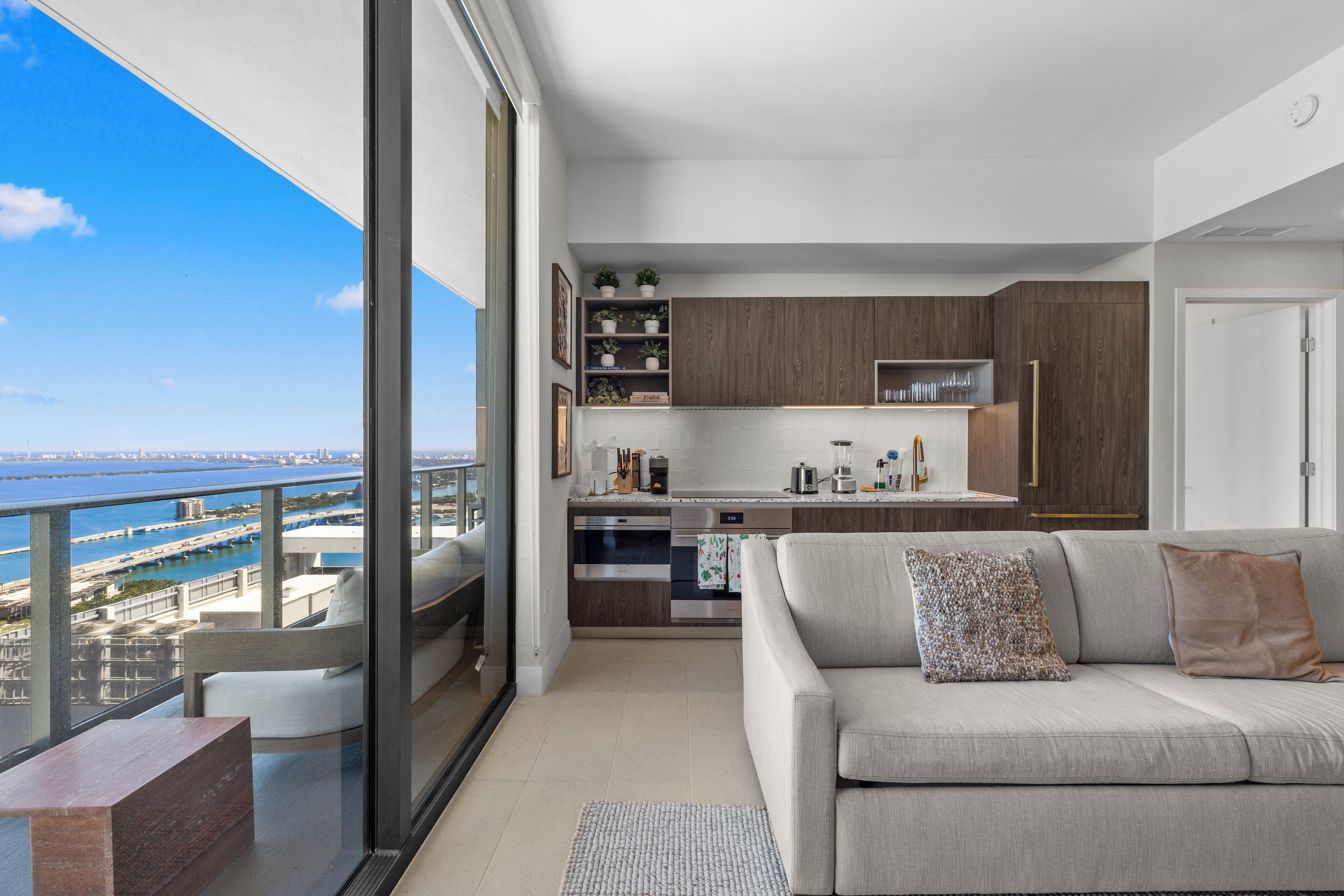 Un apartamento moderno con balcón, cocina y sala de estar.